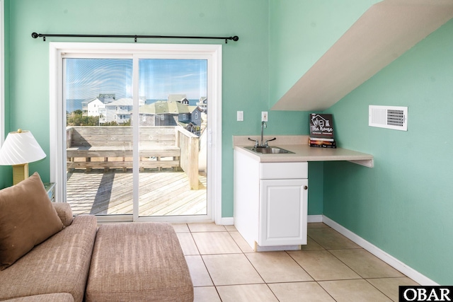 entryway featuring visible vents, a sink, baseboards, and light tile patterned flooring