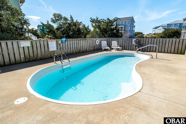 pool with a residential view and fence