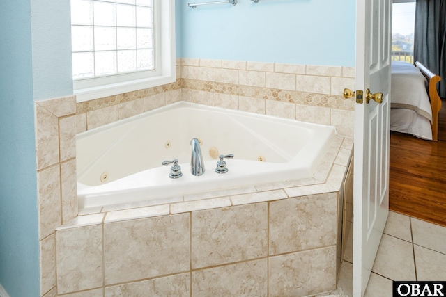 bathroom featuring ensuite bathroom, a whirlpool tub, and tile patterned floors