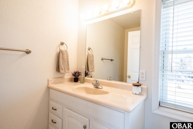 bathroom featuring a textured wall and vanity