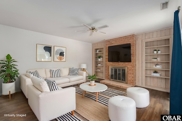 3002 Seahorse Ct Unit 3002, Kitty Hawk, NC 27949 - living area with wood finished floors, built in shelves, a ceiling fan, and a fireplace