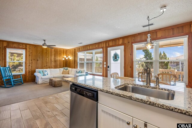 kitchen with decorative light fixtures, visible vents, stainless steel dishwasher, white cabinets, and a sink