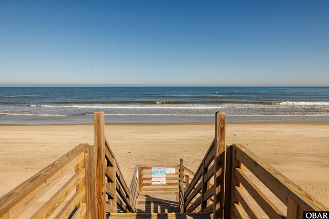 surrounding community featuring a water view and a beach view