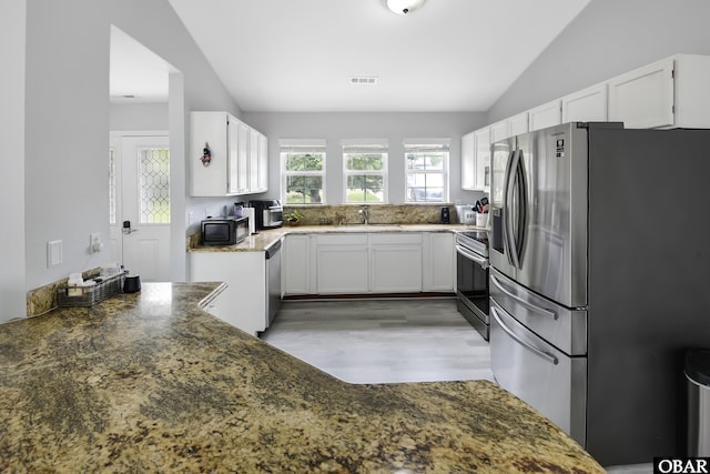 192 Colingwood Ln Lot 22, Kill Devil Hills, NC 27948 - kitchen with stainless steel appliances, lofted ceiling, white cabinetry, light wood-type flooring, and dark stone counters