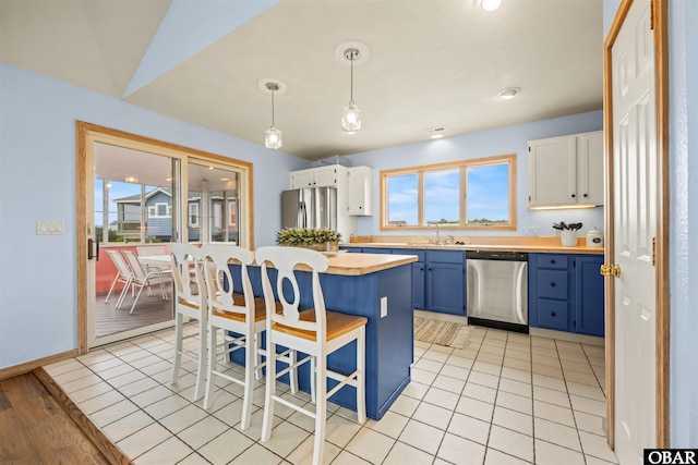 903 Windward Way Lot 15, Corolla, NC 27927 - kitchen featuring stainless steel appliances, blue cabinetry, a kitchen breakfast bar, and healthy amount of natural light