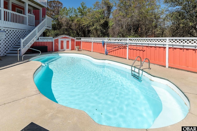 903 Windward Way Lot 15, Corolla, NC 27927 - view of pool with a fenced backyard, a storage unit, stairs, an outdoor structure, and view of wooded area