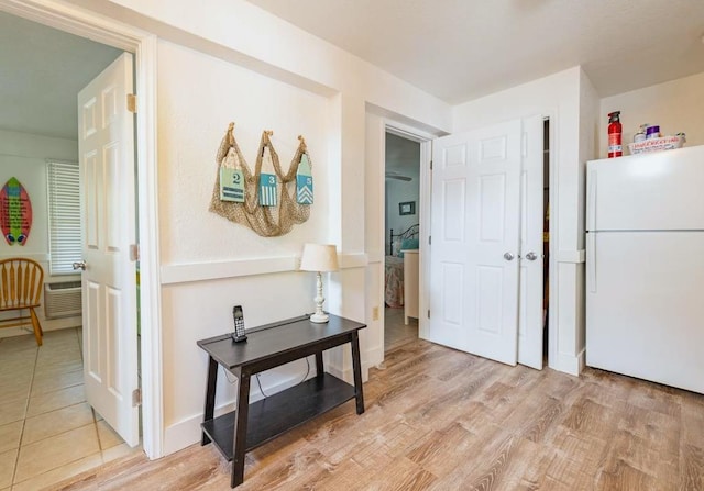 corridor featuring baseboards and light wood finished floors