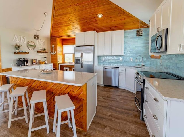 kitchen featuring a sink, stainless steel appliances, a kitchen breakfast bar, and tasteful backsplash