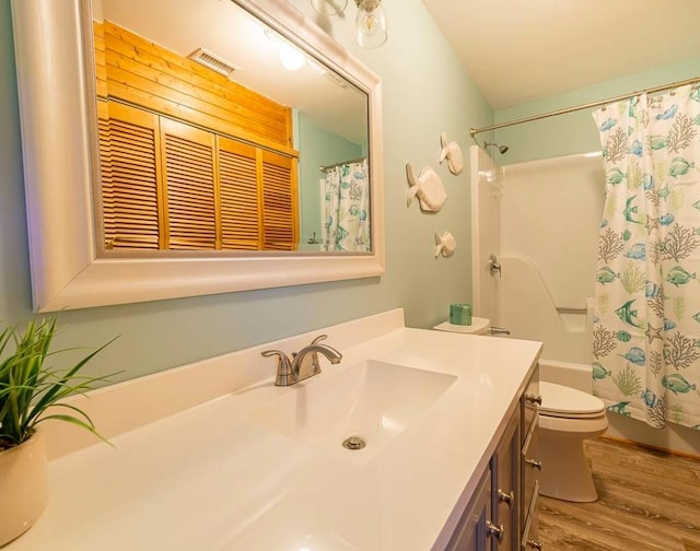 full bathroom featuring visible vents, toilet, wood finished floors, vanity, and shower / bathtub combination with curtain