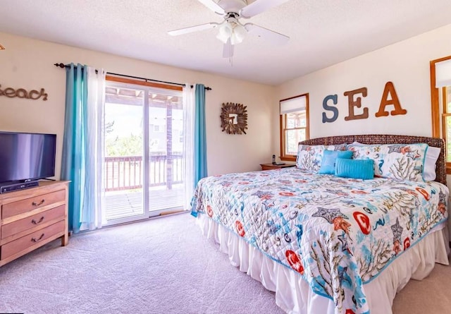 carpeted bedroom with access to exterior, multiple windows, and a textured ceiling