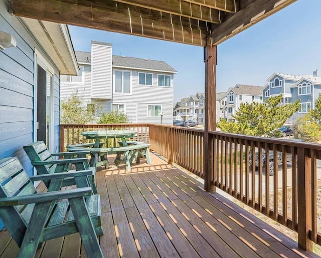 wooden deck with a residential view and outdoor dining area