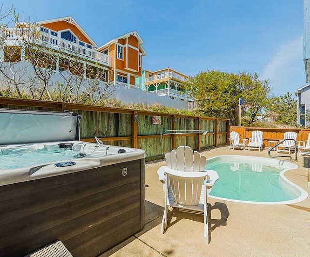 view of swimming pool featuring a patio area, a fenced in pool, a fenced backyard, and a hot tub