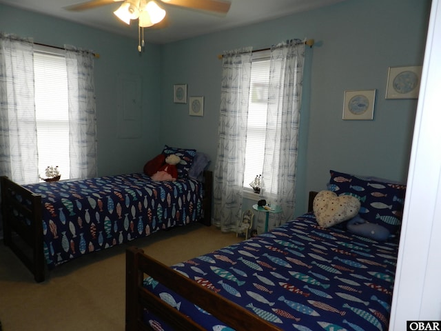 bedroom with multiple windows, ceiling fan, and carpet flooring