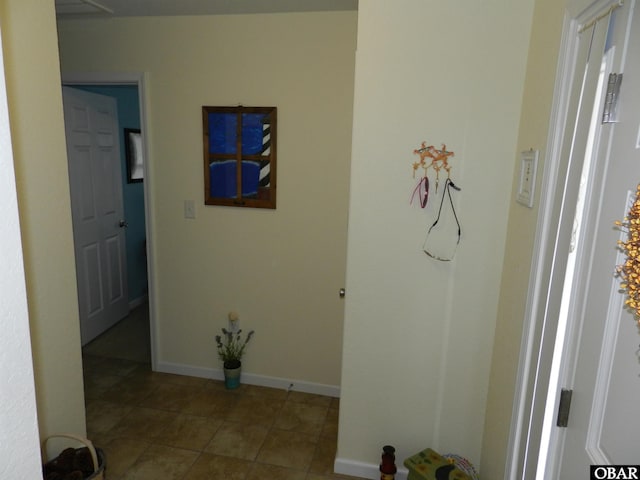 hall featuring baseboards and tile patterned floors