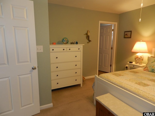 bedroom featuring light carpet and baseboards