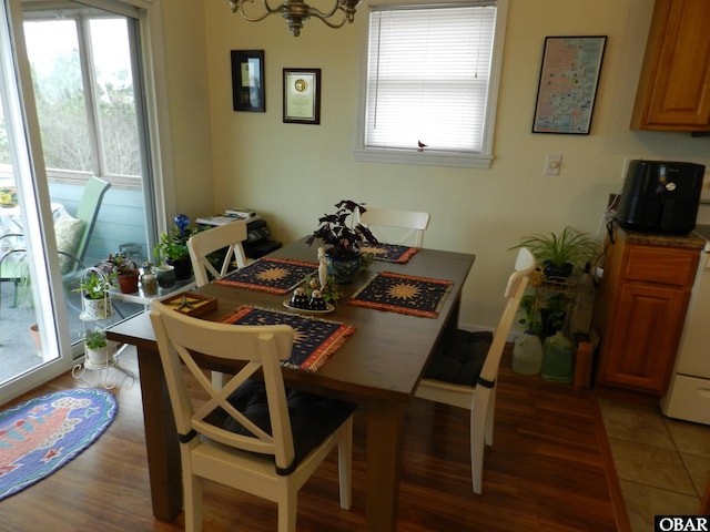 dining area with a chandelier, light wood-type flooring, and a wealth of natural light