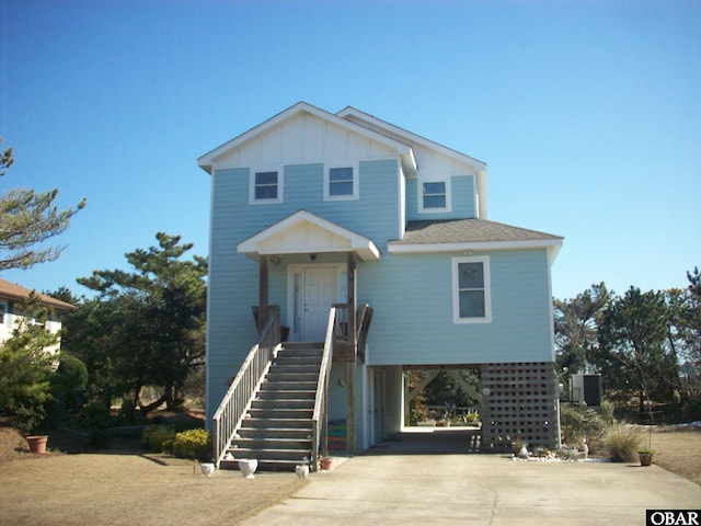 view of front of house with a carport, driveway, stairway, and board and batten siding