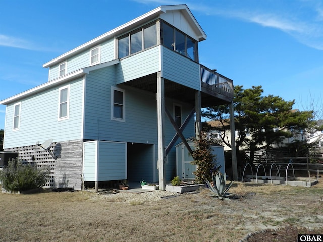 rear view of property with a sunroom and a wooden deck