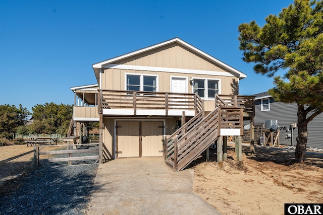 view of front facade with driveway, stairs, and board and batten siding