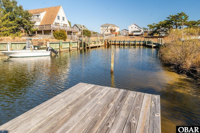 view of dock with a water view and a residential view