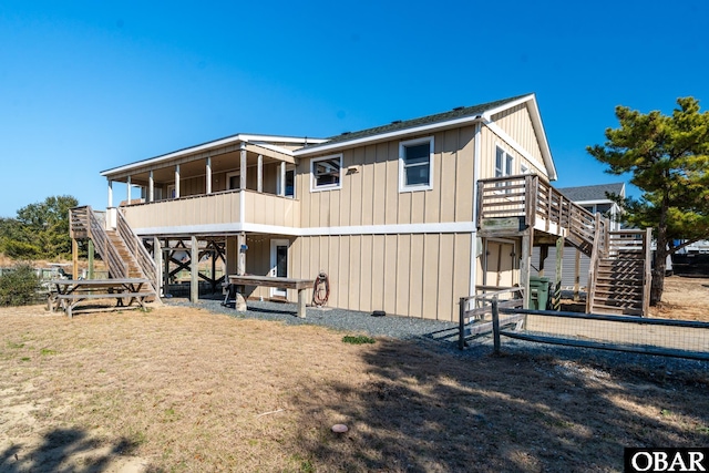 back of property with stairs and board and batten siding