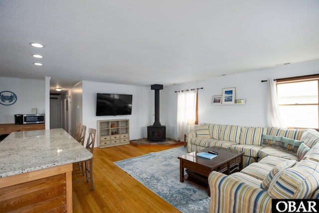 living room with light wood-type flooring, a wood stove, visible vents, and recessed lighting