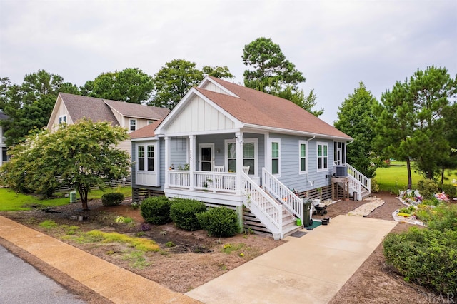 view of front of property featuring board and batten siding, covered porch, roof with shingles, and central AC unit