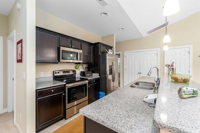 kitchen with a kitchen island with sink, stainless steel appliances, a sink, visible vents, and hanging light fixtures