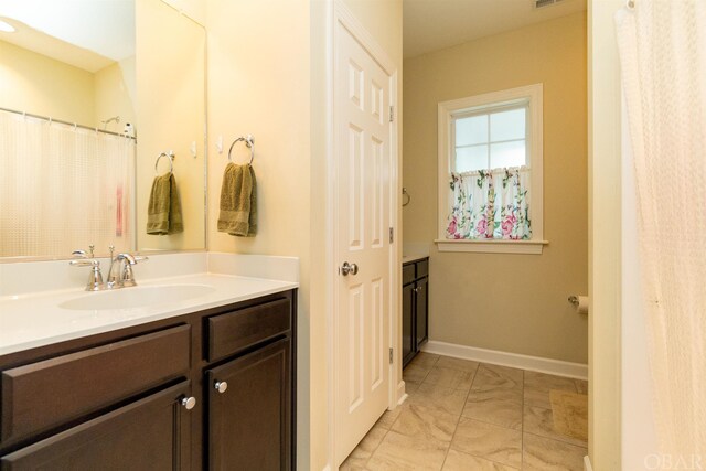 bathroom with marble finish floor, visible vents, vanity, and baseboards
