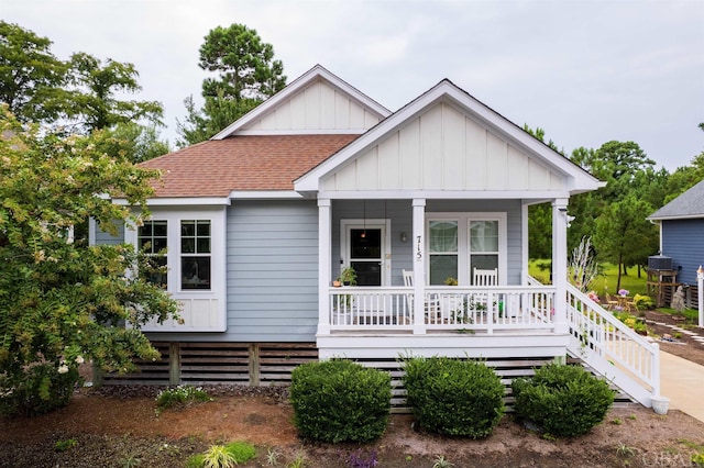 view of front of property with covered porch, roof with shingles, and board and batten siding