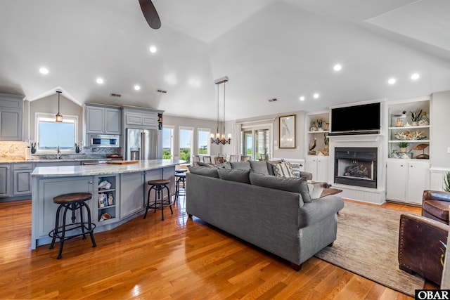 4311 S Hesperides Dr Lot # 55, Nags Head, NC 27959 - living room with light wood-type flooring, a fireplace with raised hearth, lofted ceiling, and a wealth of natural light