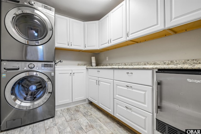 4311 S Hesperides Dr Lot # 55, Nags Head, NC 27959 - clothes washing area with cabinet space, light wood-type flooring, and stacked washer / dryer