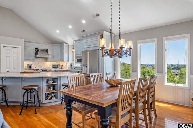 4311 S Hesperides Dr Lot # 55, Nags Head, NC 27959 - dining area with visible vents, lofted ceiling, a toaster, light wood-style floors, and a notable chandelier