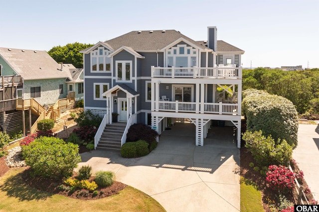 4311 S Hesperides Dr Lot # 55, Nags Head, NC 27959 - beach home featuring roof with shingles, stairs, a balcony, a carport, and driveway