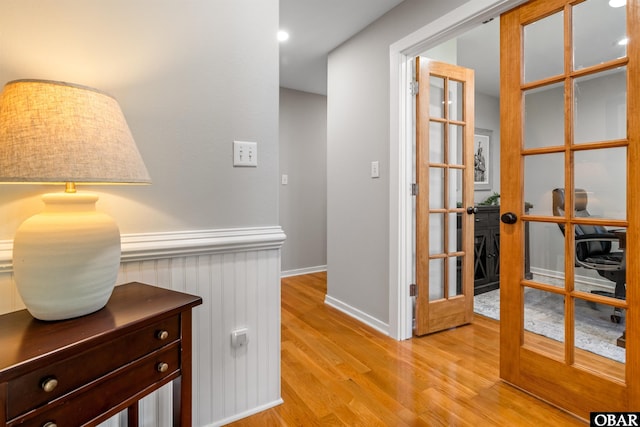 4311 S Hesperides Dr Lot # 55, Nags Head, NC 27959 - hallway with light wood-type flooring, a wainscoted wall, and french doors