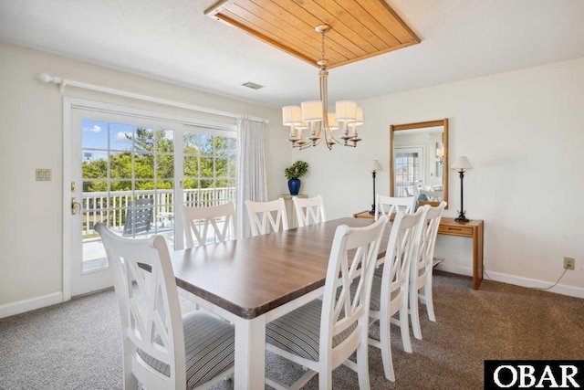 carpeted dining room with visible vents, baseboards, and an inviting chandelier
