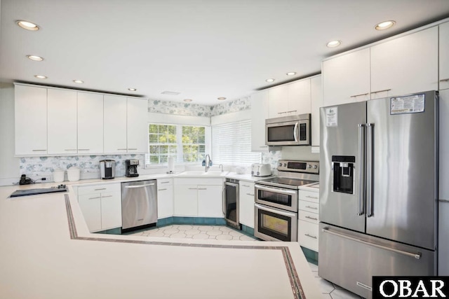 kitchen featuring recessed lighting, white cabinetry, stainless steel appliances, and a sink