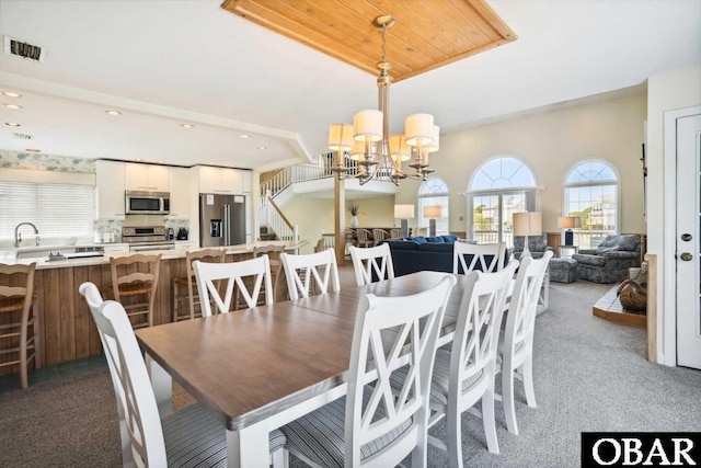 dining space featuring a chandelier, visible vents, light colored carpet, and recessed lighting