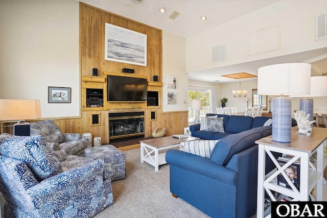 living room featuring carpet flooring, visible vents, wood walls, and wainscoting