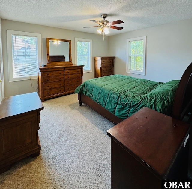 25 Croatan Ct Unit 25, Manteo, NC 27954 - bedroom with carpet flooring, multiple windows, a textured ceiling, and a ceiling fan