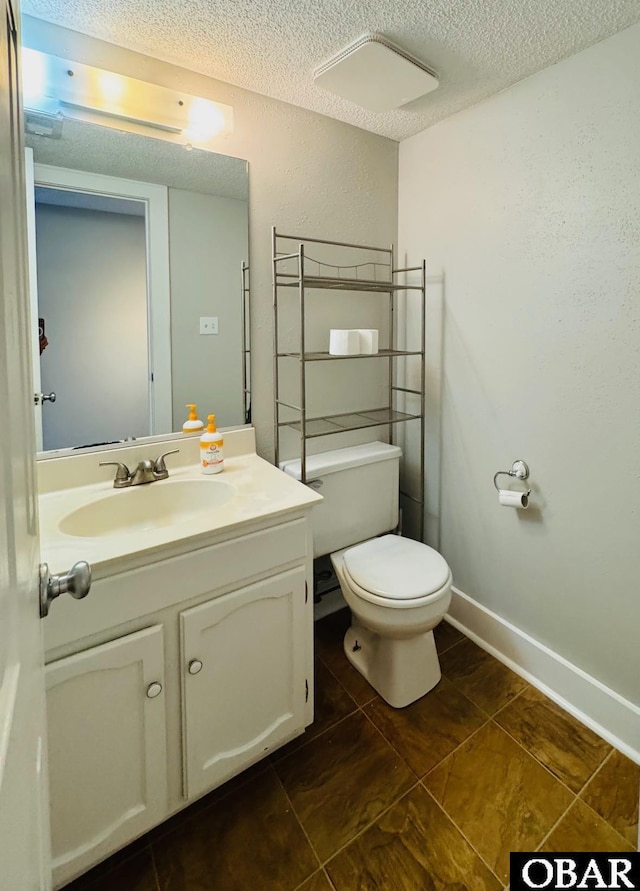 25 Croatan Ct Unit 25, Manteo, NC 27954 - bathroom featuring a textured ceiling, vanity, toilet, tile patterned flooring, and baseboards