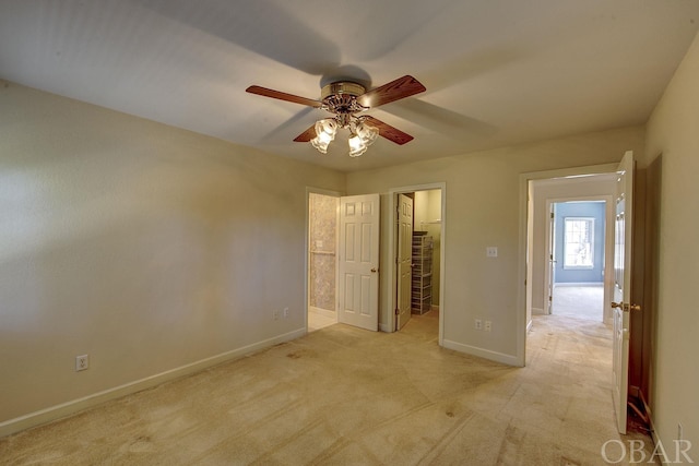 unfurnished bedroom featuring light carpet, baseboards, ceiling fan, a spacious closet, and a closet