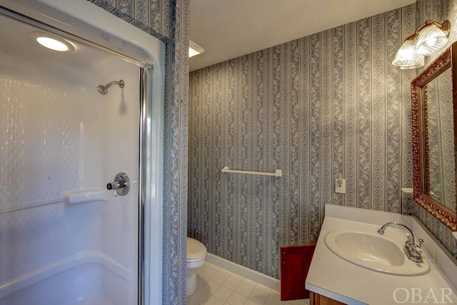 full bath featuring toilet, vanity, a shower stall, baseboards, and wallpapered walls