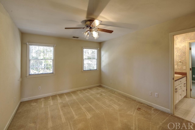 unfurnished room featuring light colored carpet, ceiling fan, visible vents, and baseboards