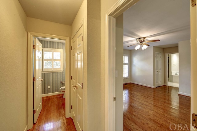 hallway featuring wood finished floors and baseboards