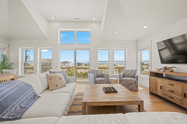 living room featuring light wood-style floors, visible vents, a wealth of natural light, and recessed lighting