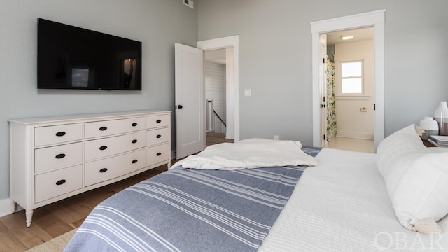 bedroom featuring dark wood-style flooring and ensuite bath