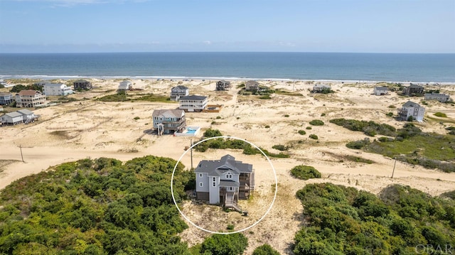 birds eye view of property with a water view and a beach view