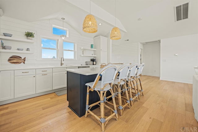 kitchen featuring visible vents, pendant lighting, light countertops, white cabinetry, and open shelves