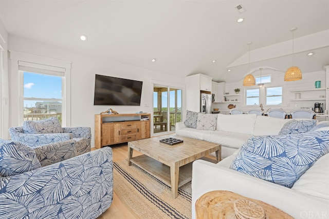 living area featuring light wood-style floors, visible vents, vaulted ceiling, and recessed lighting